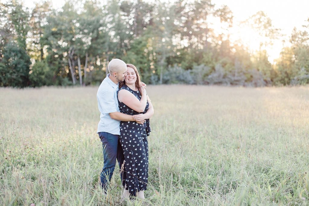 he has her wrapped up in his arms in the middle of the field at sunset at the mill of kintail in almonte 