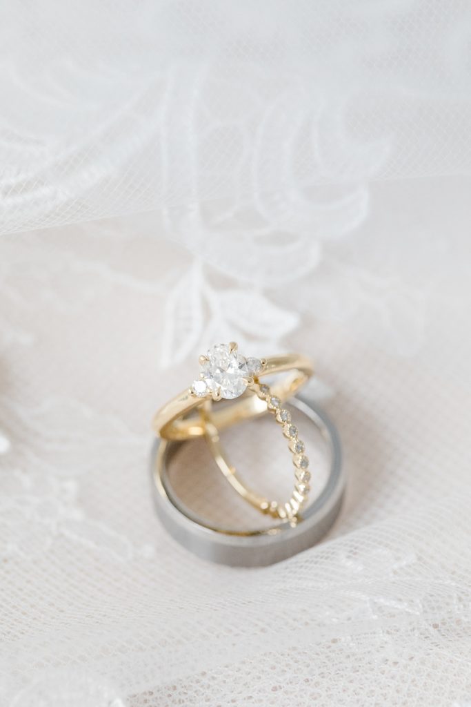 la maison d'or wedding rings stacked on wedding dress during bridal details photos at petite backyard wedding