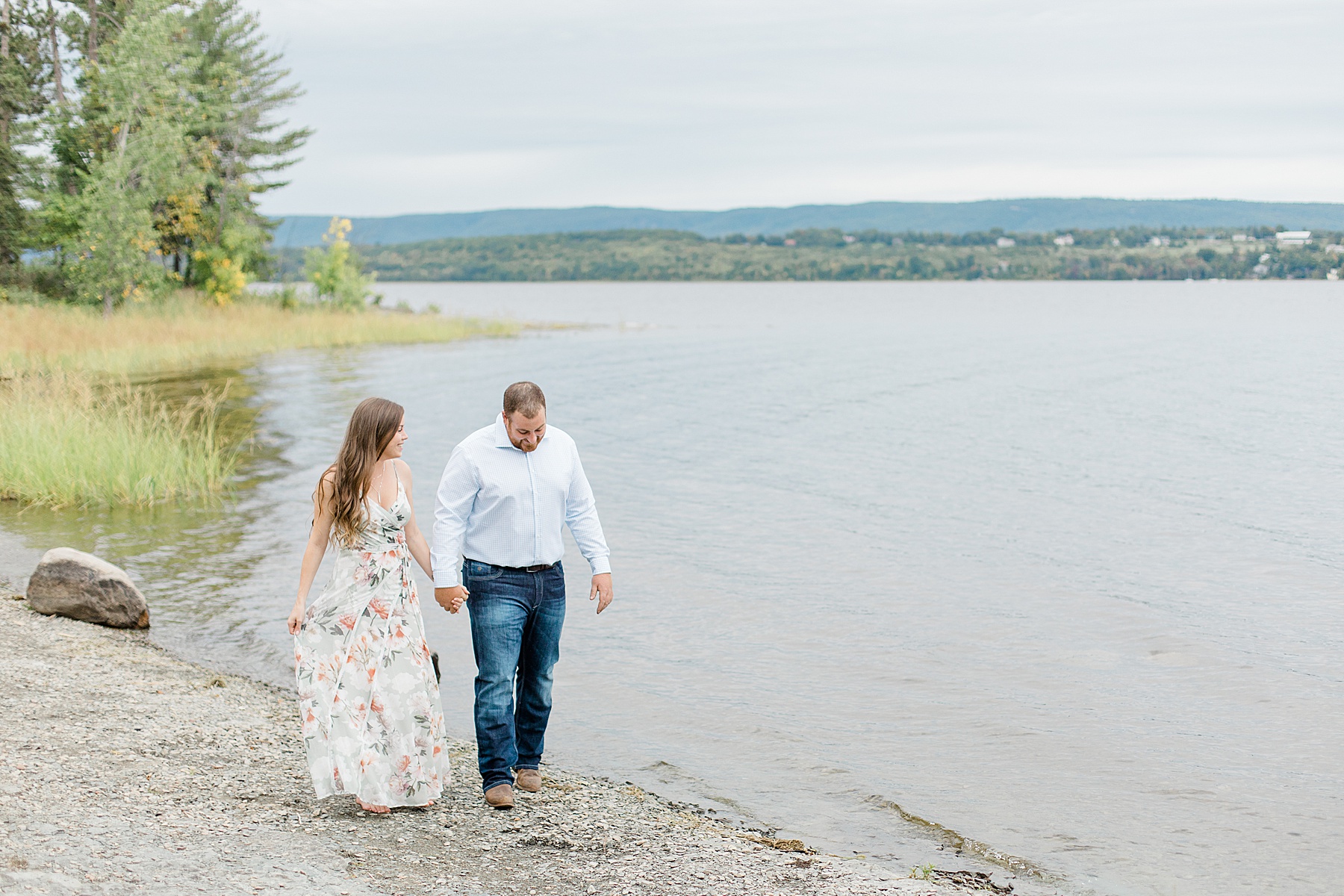 couple walking along the water at pinheys point in dunrobin