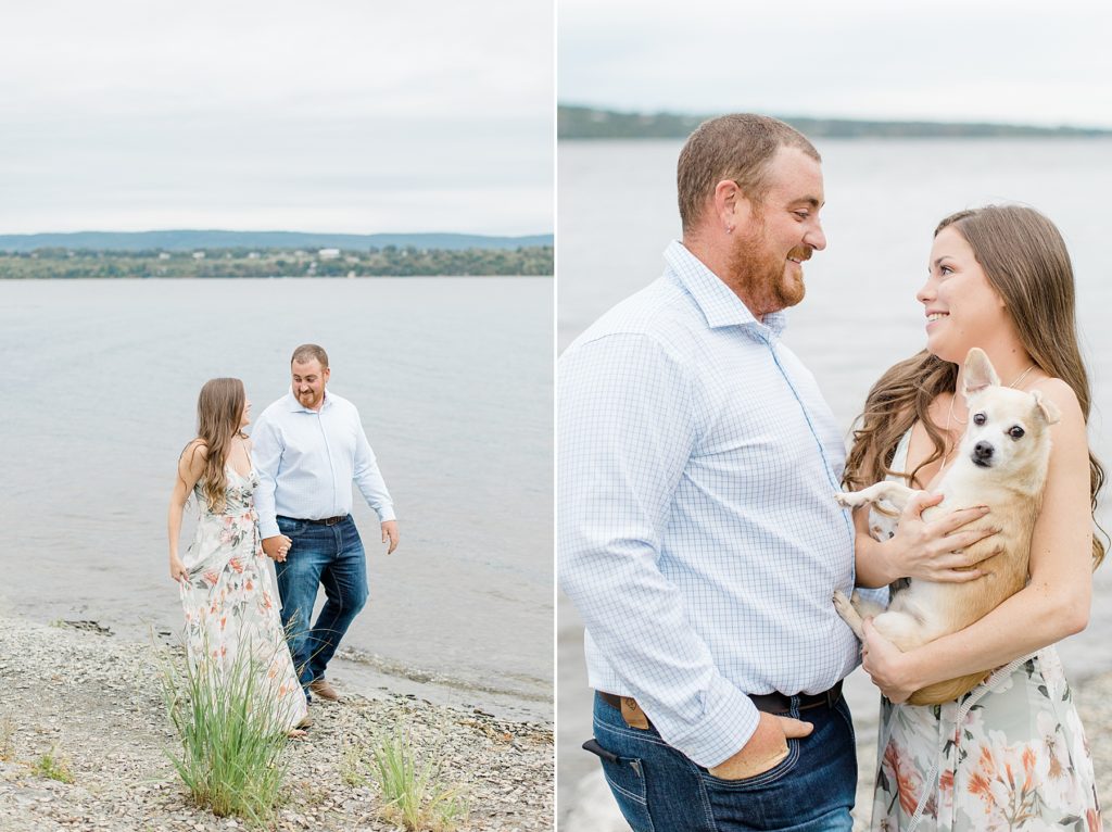 couple by the water with their puppy during an engagement session at pinheys point