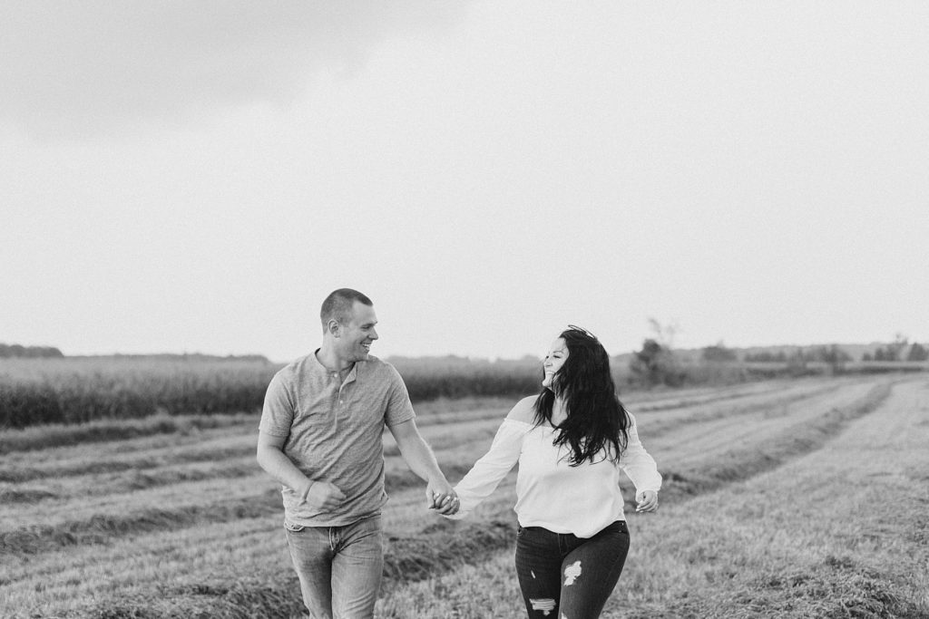 couple running through the hay field together