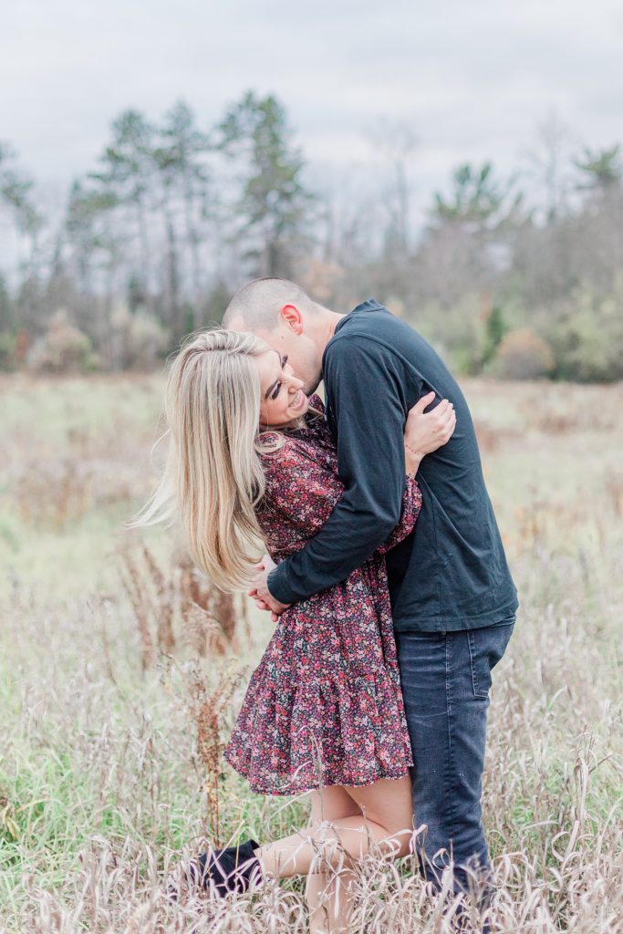 couple embracing in the middle of the field in almonte