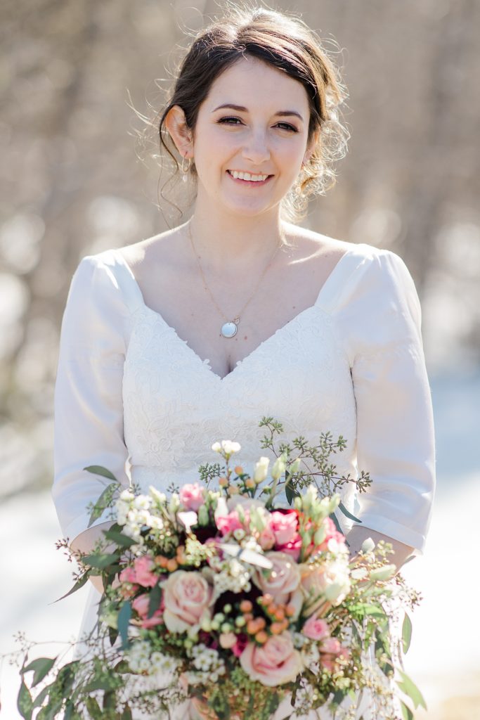 Portrait of the bride on her wedding day holding her spring florals