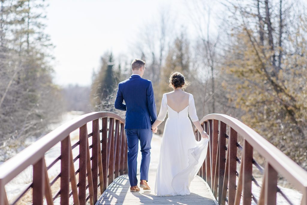 Bride and groom walking away on a cute bridge in Stittsville Ontario