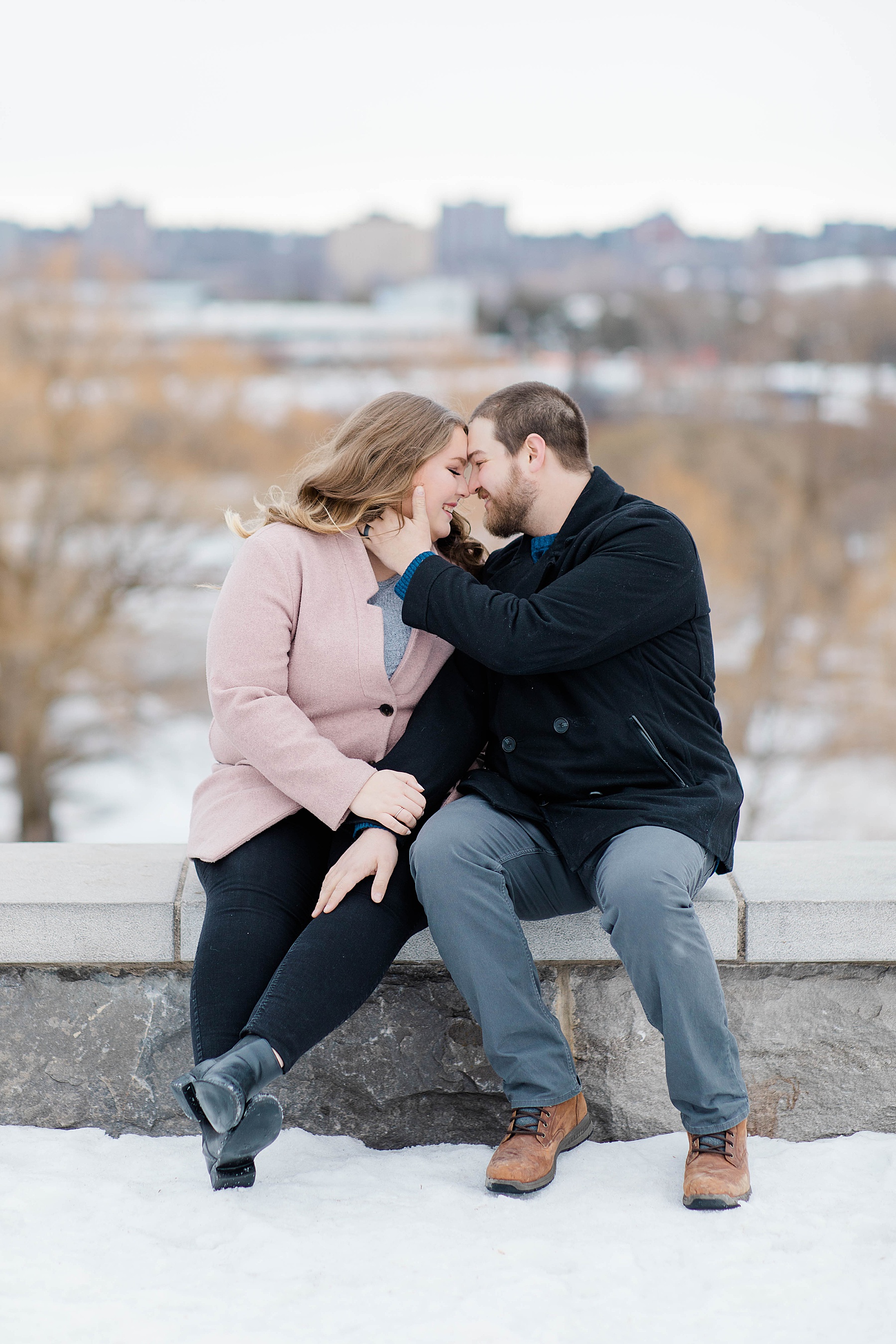 engaged couple sitting together at winter engagement session