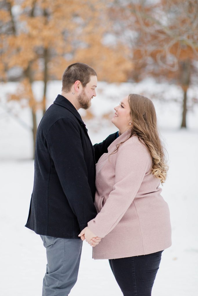 couple facing each other holding hands and looking at one another at ottawa engagement session