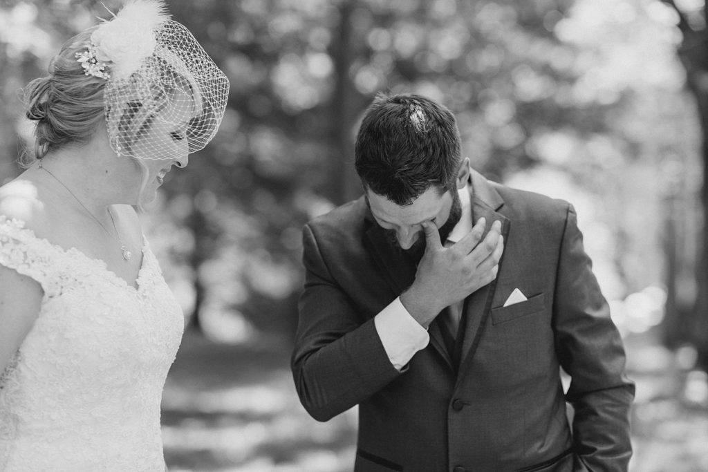 groom is tearing up as he sees his bride for the first time during their first look