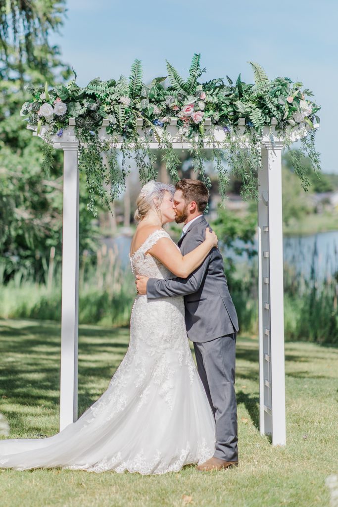 bride and groom's first kiss during ceremony at carleton golf and yacht club wedding