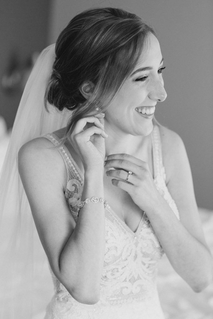 bride putting on her earings at Brookstreet Hotel Wedding in Ottawa with Brittany Navin Photography