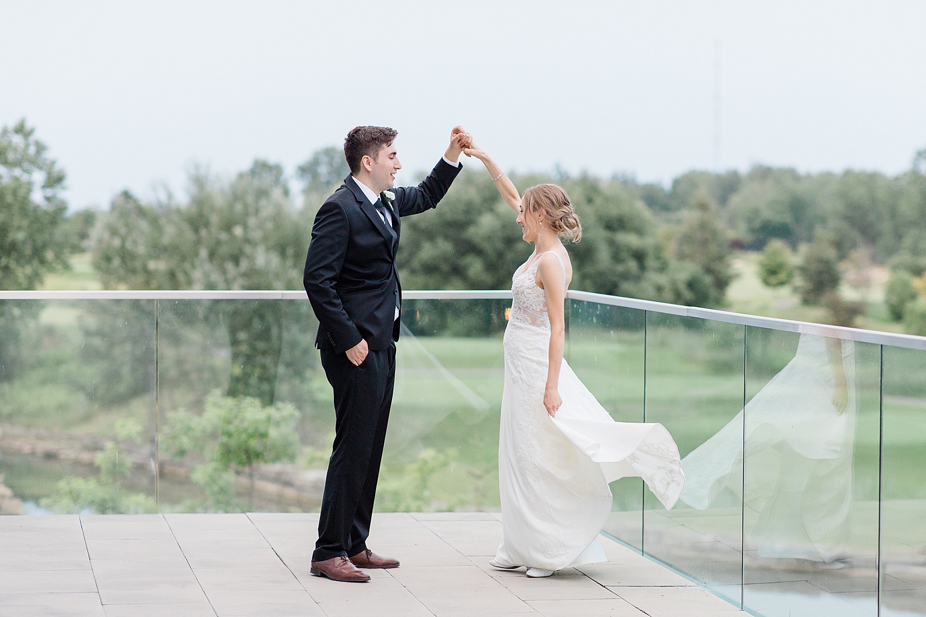 bride and groom dancing on balcony at Brookstreet Hotel Wedding in Ottawa with Brittany Navin Photography