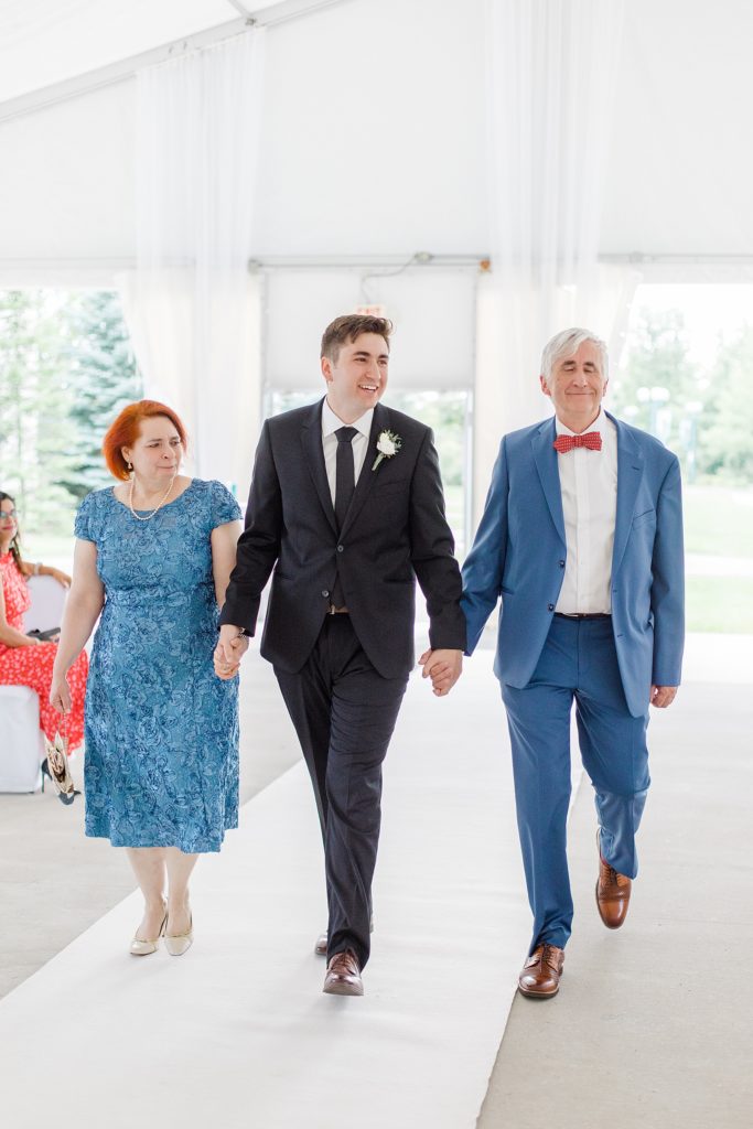 groom coming down the aisle with both of his parents during ceremony at wedding in Ottawa with Brittany Navin Photography