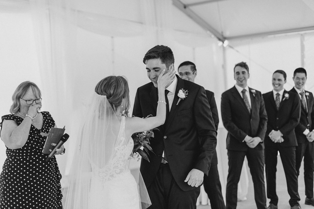 bride wiping away grooms tears at beginning of ceremony at Brookstreet Hotel Wedding in Ottawa with Brittany Navin Photography