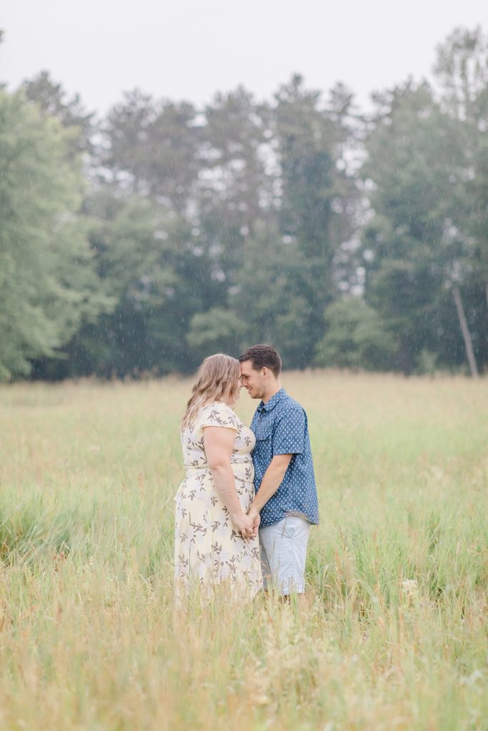 couple forehead to forehead in the rain during Almonte engagment session with Brittany Navin Photography