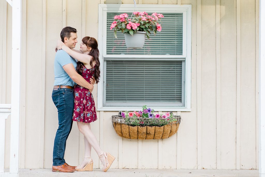 couple with arms around each other under the porch at their engagement at the Mill of Kintail with Brittany Navin Photography