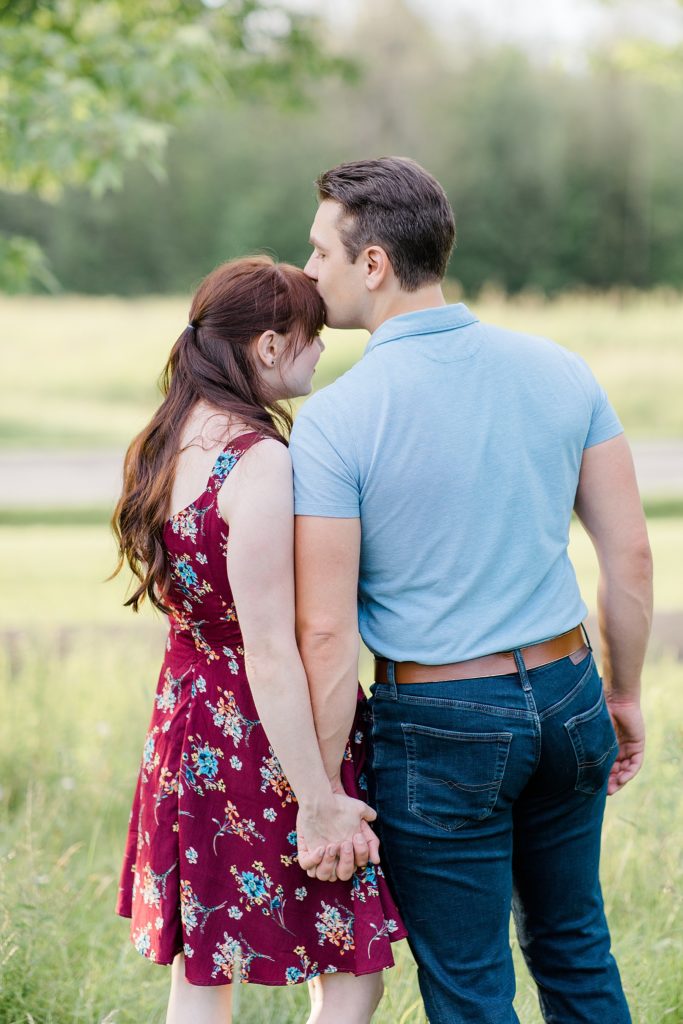 he is sneaking in a forehead kiss at their engagement in Almonte, ON, at the Mill of Kintail with Brittany Navin Photography