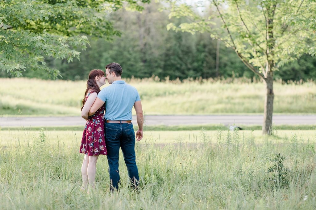 couple with arms around each other at their engagement in Almonte, ON, at the Mill of Kintail with Brittany Navin Photography