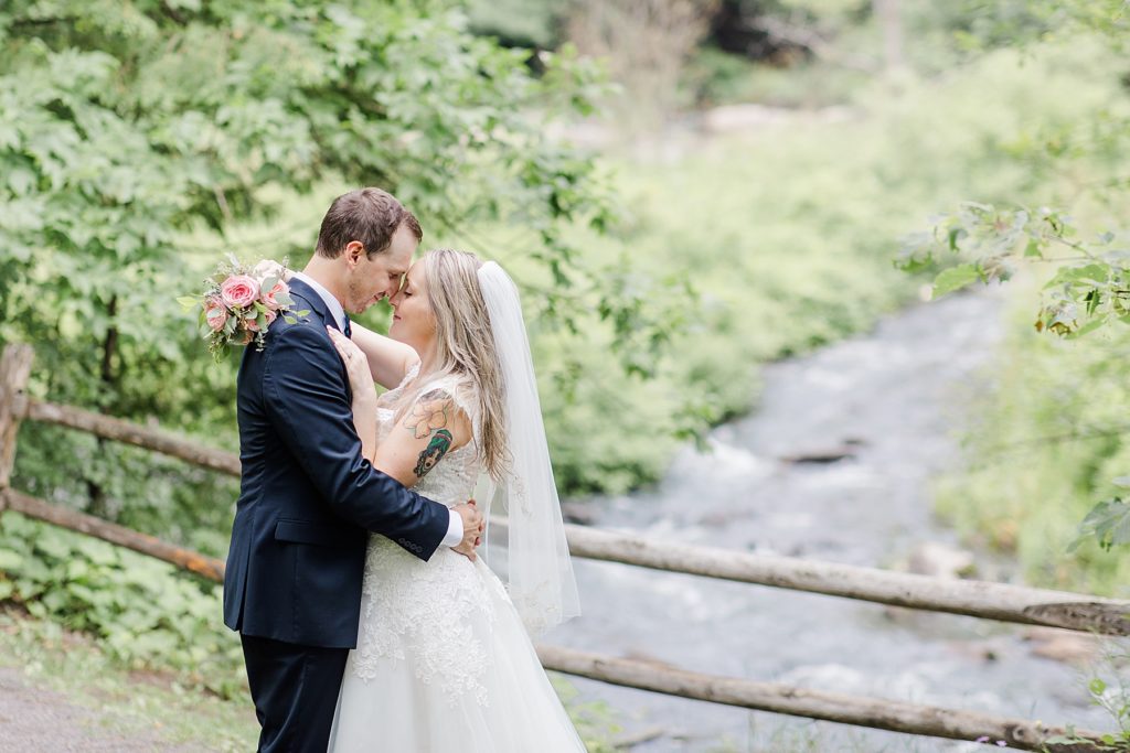 bride and groom sharing a moment by the water at Mill of Kintail Wedding with Brittany Navin Photography in Almonte, Ontario