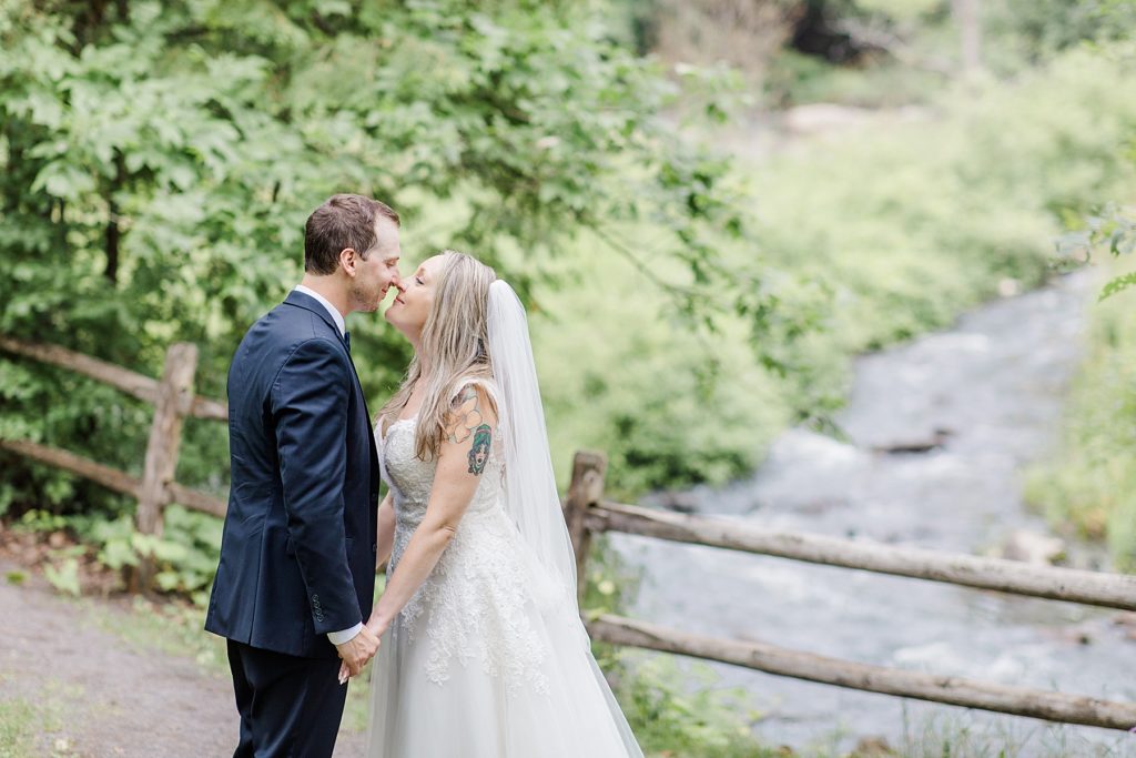 bride and groom sharing a moment by the water at Mill of Kintail Wedding with Brittany Navin Photography in Almonte, Ontario