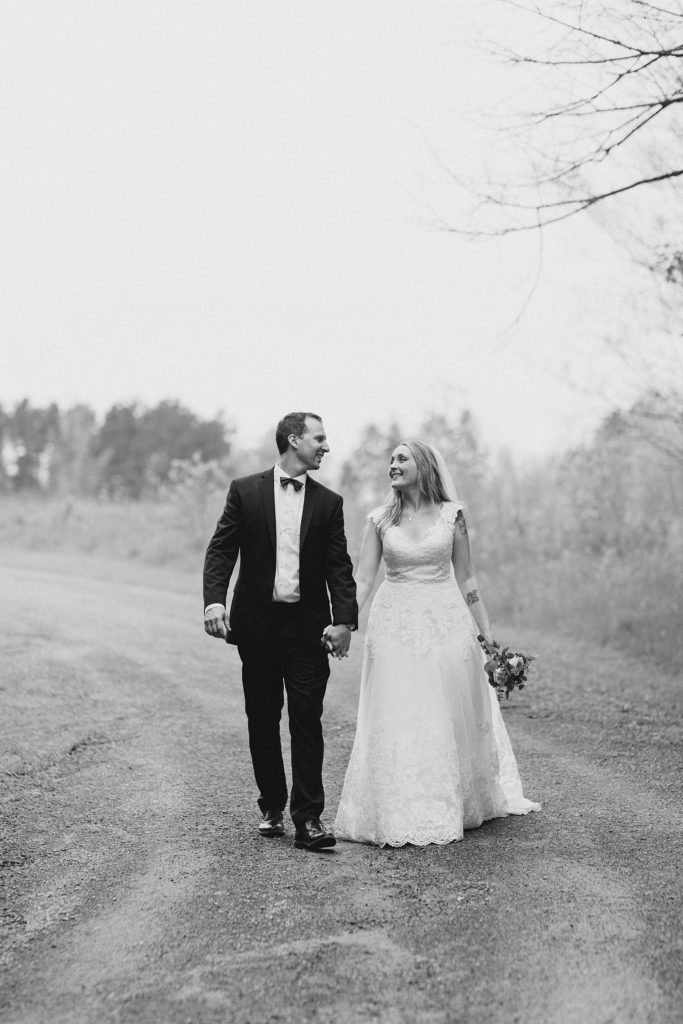 bride and groom walking on a trail at Mill of Kintail Wedding with Brittany Navin Photography in Almonte, Ontario