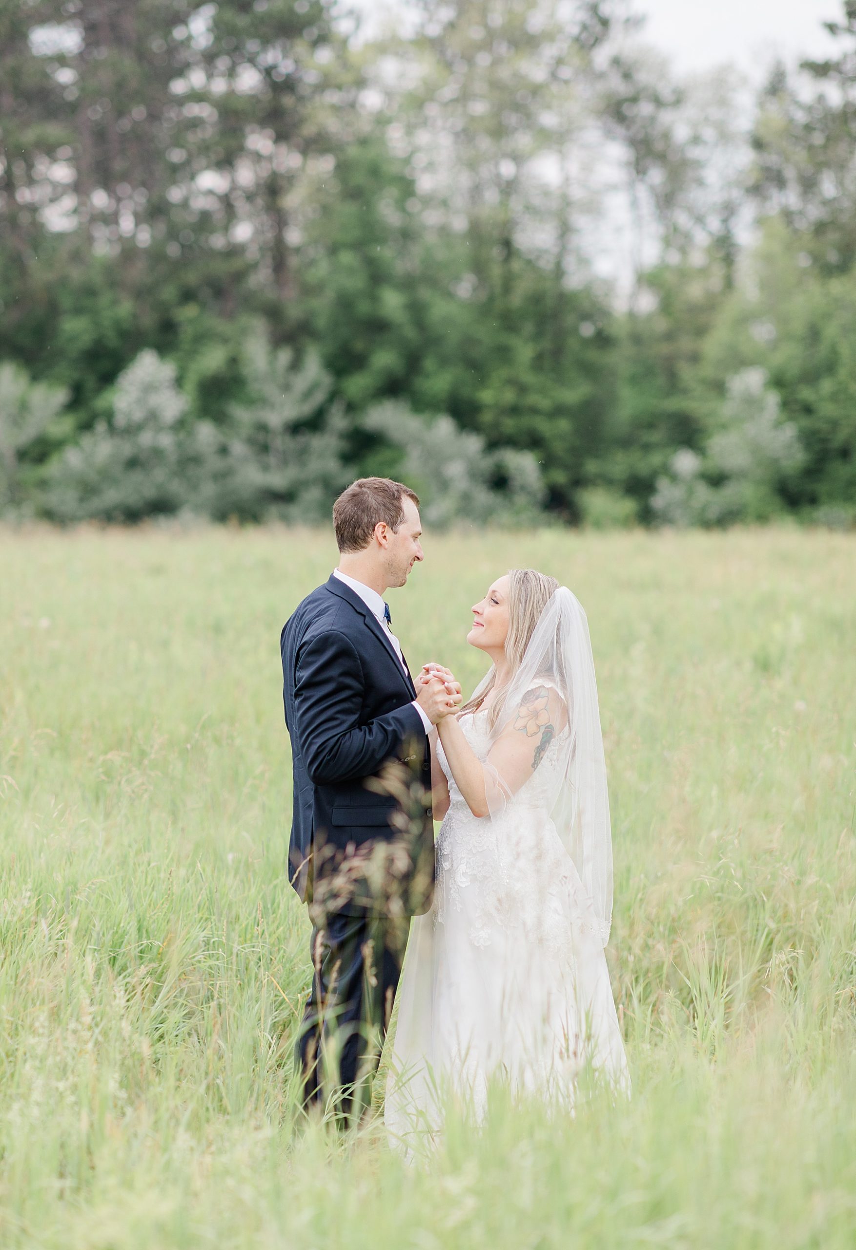 bride and groom sharing a moemnt in field at Mill of Kintail Wedding with Brittany Navin Photography in Almonte, Ontario