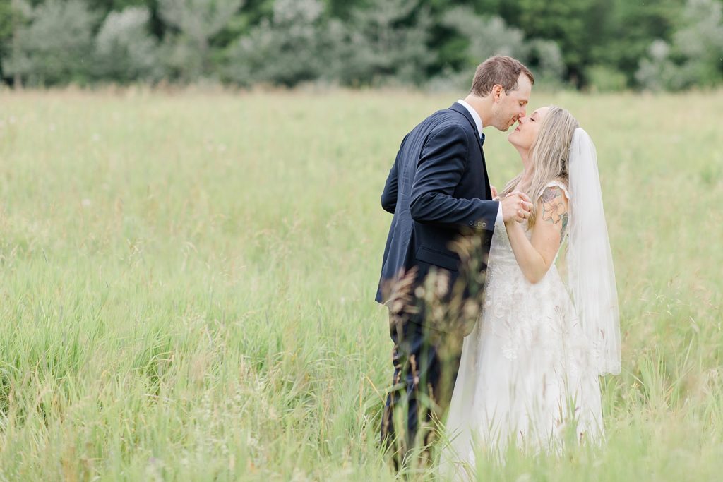 bride and groom in the middle of a field at Mill of Kintail Wedding with Brittany Navin Photography in Almonte, Ontario