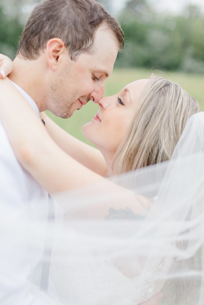 bride and groom nose to nose with veil in the foreground at Mill of Kintail Wedding with Brittany Navin Photography in Almonte, Ontario