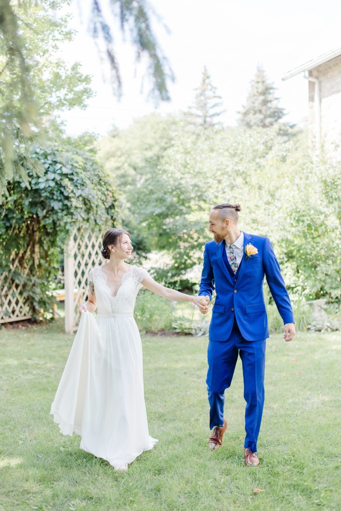 bride and groom walking At The Schoolhouse wedding in munster ontario photographed by Brittany Navin Photography