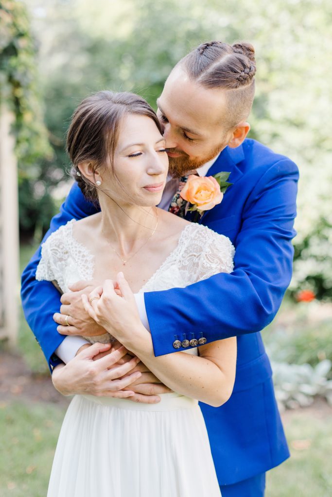 groom has bride wrapped up At The Schoolhouse wedding in munster ontario photographed by Brittany Navin Photography