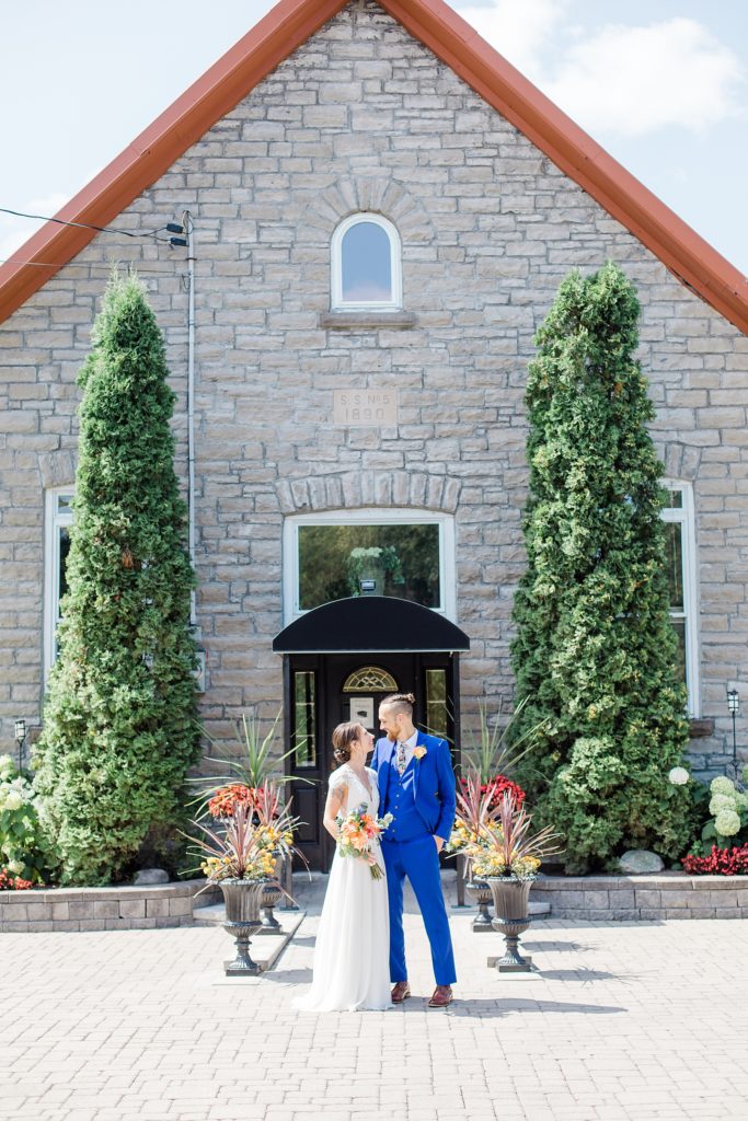 bride and groom in front of the schoolhouse At The Schoolhouse wedding in munster ontario photographed by Brittany Navin Photography