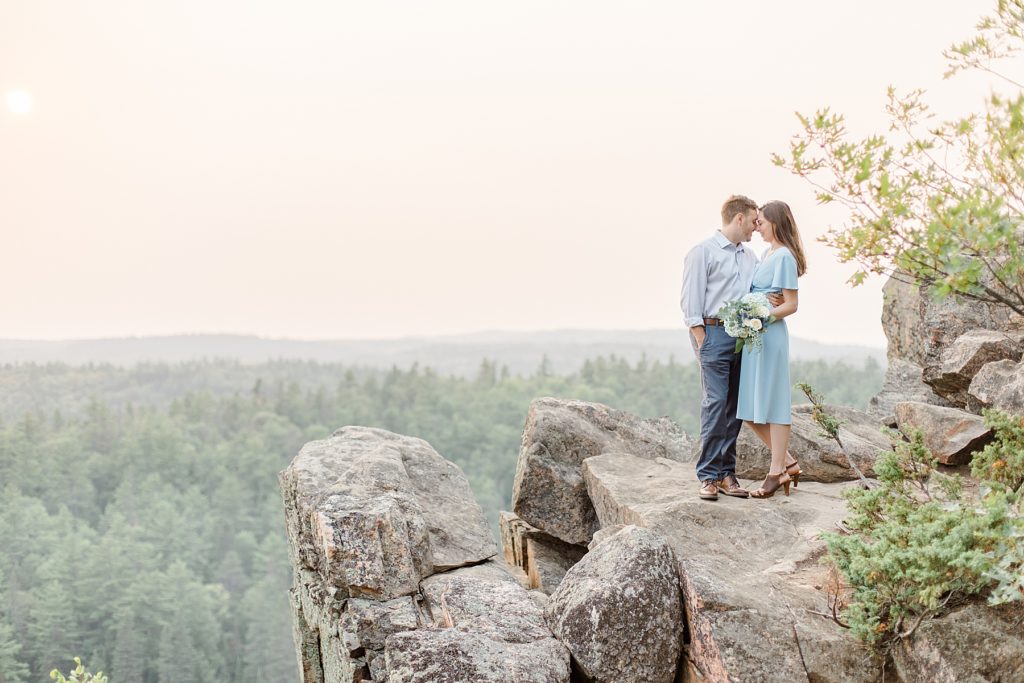 couple is standing cliff side at Eagle's Nest Lookout Engagement in Calabogie, Ontario with Brittany Navin Photography