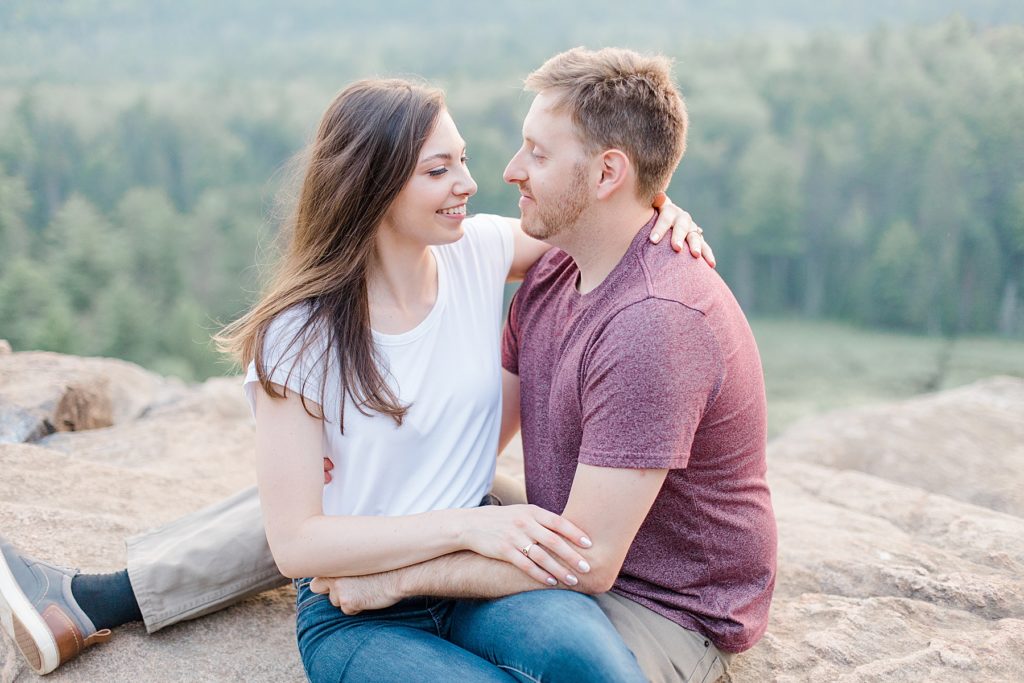 couple sitting together cliff side at calbogie engagement session