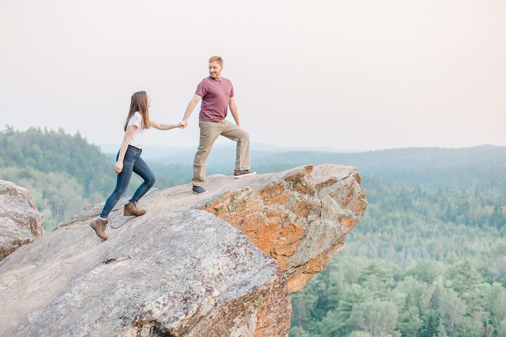couple up on a rocky cliff at Eagle's Nest Lookout Engagement in Calabogie, Ontario with Brittany Navin Photography