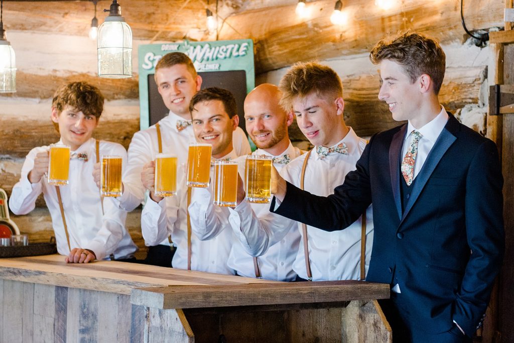 groom and groomsmen having beer at Temple's Sugar Bush Wedding Photographed by Brittany Navin