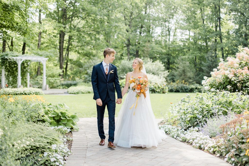 bride and groom walking hand in hand at Temple's Sugar Bush Wedding Photographed by Brittany Navin