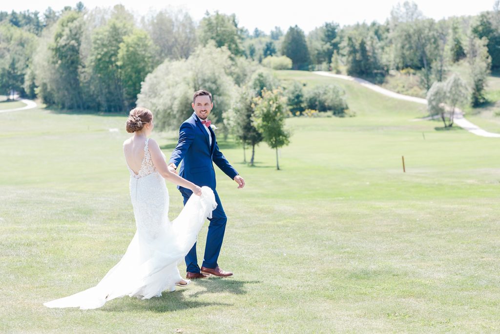 bride and groom walking at timber run golf course wedding in Lanark, Ontario photographed by Brittany Navin
