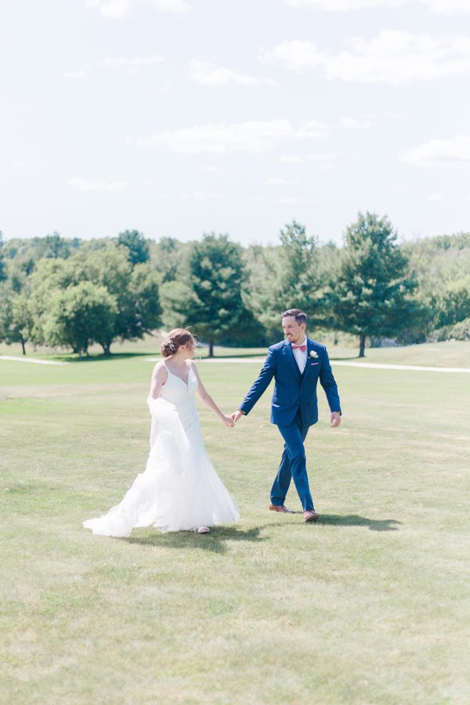 bride and groom walking at timber run golf course wedding in Lanark, Ontario photographed by Brittany Navin