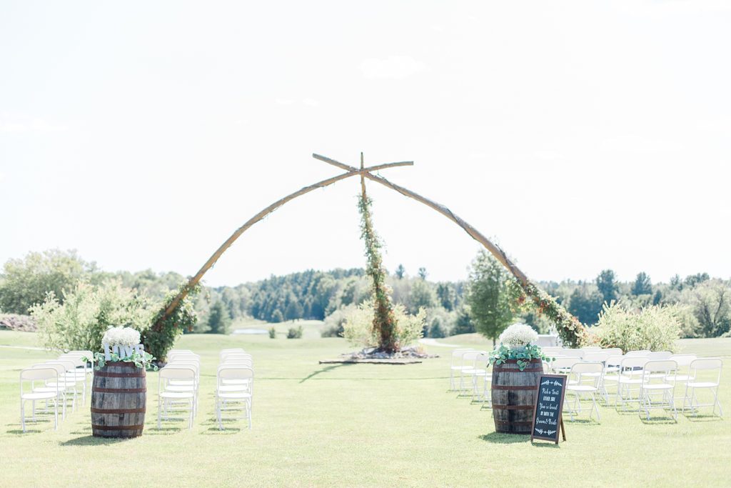 ceremony set up of wooden arch at timber run golf course wedding in Lanark, Ontario photographed by Brittany Navin