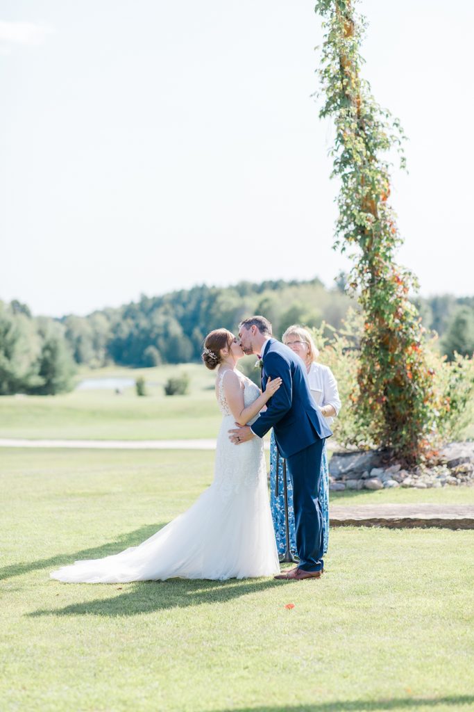 bride and groom first kiss at timber run golf course wedding in Lanark, Ontario photographed by Brittany Navin