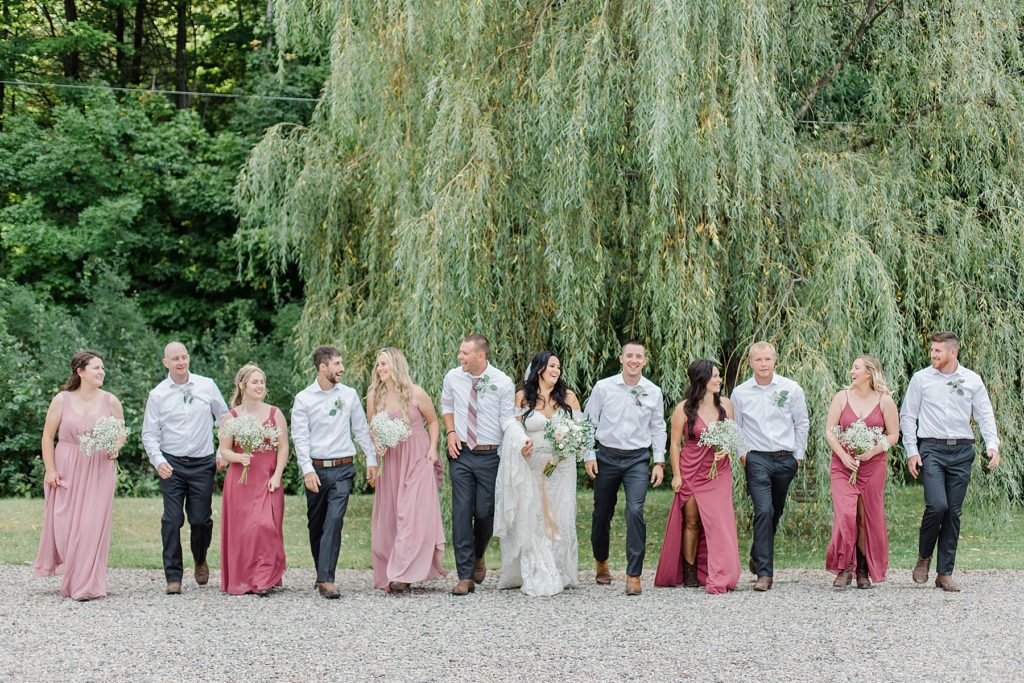 full wedding party walking togeher, bridesmaids are wearing light pink and dusty rose at Adelina Barn Wedding Photographed By Brittany Navin Photography