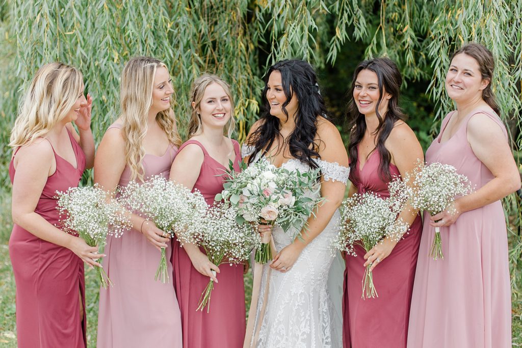 bride with bridemaids wearing light pink and dusty rose at Adelina Barn Wedding Photographed By Brittany Navin Photography