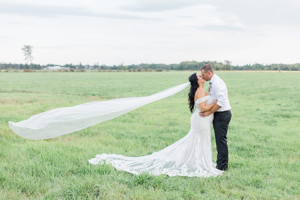 flying veil husband and wife portrait at Adelina Barn Wedding Photographed By Brittany Navin Photography
