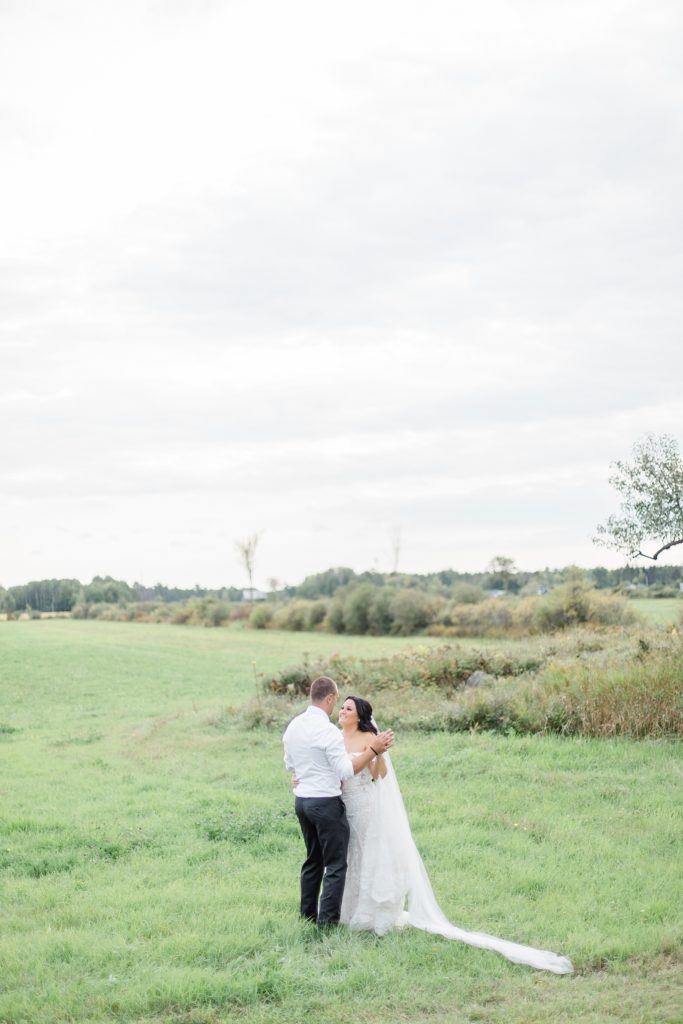 bride and groom dancing in the field at Adelina Barn Wedding Photographed By Brittany Navin Photography
