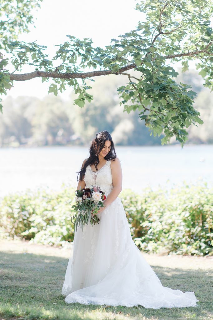 bridal portrait wearing sinders bridal house dress and holding florals from ramsay creek at Riverside Park Wedding in Carleton Place photographed by Brittany Navin Photography
