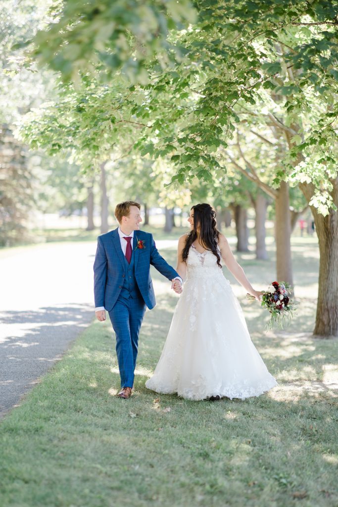bride and groom walking at Riverside Park Wedding in Carleton Place photographed by Brittany Navin Photography