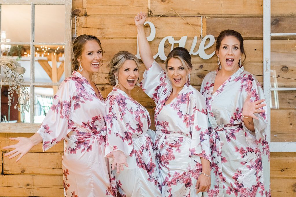 brides with their maid of honours in getting ready robes at bean town ranch double wedding photographed by Brittany Navin Photography