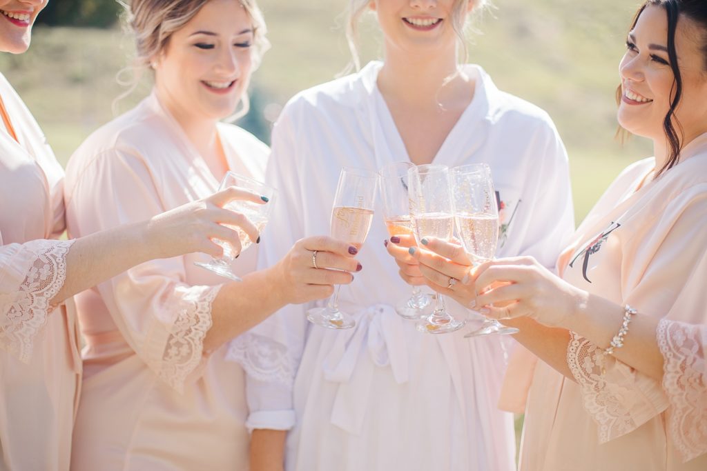 bride and bridesmaids cheers their champagne at Calabogie Peaks wedding photographed by Brittany Navin Photography