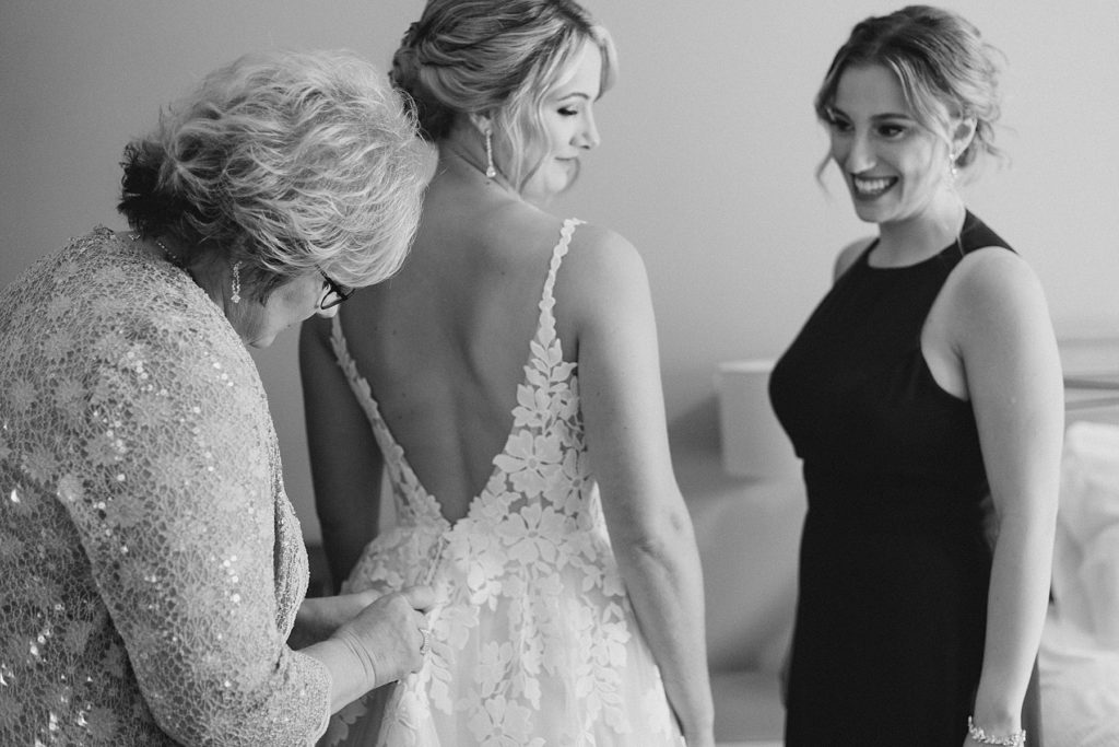 bride getting into her dress at Calabogie Peaks wedding photographed by Brittany Navin Photography
