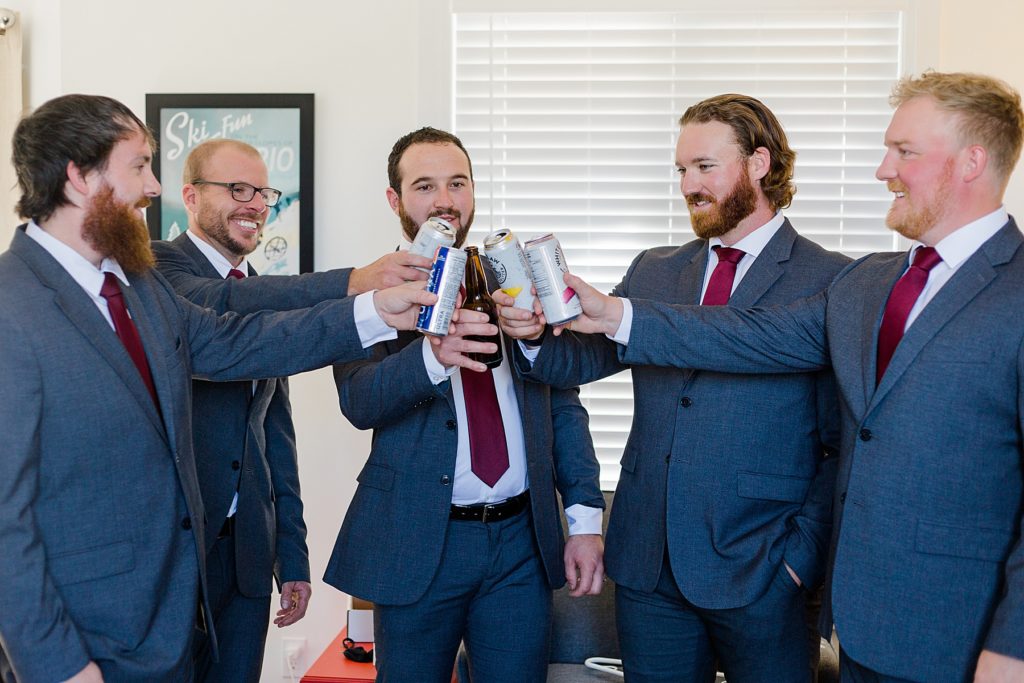 groom and groomsmen cheers in getting ready room at Calabogie Peaks wedding photographed by Brittany Navin Photography