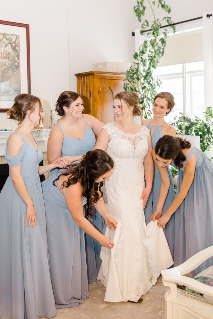 bridal party helping bride with final touches for temples country winter wedding photographed by Brittany Navin Photography