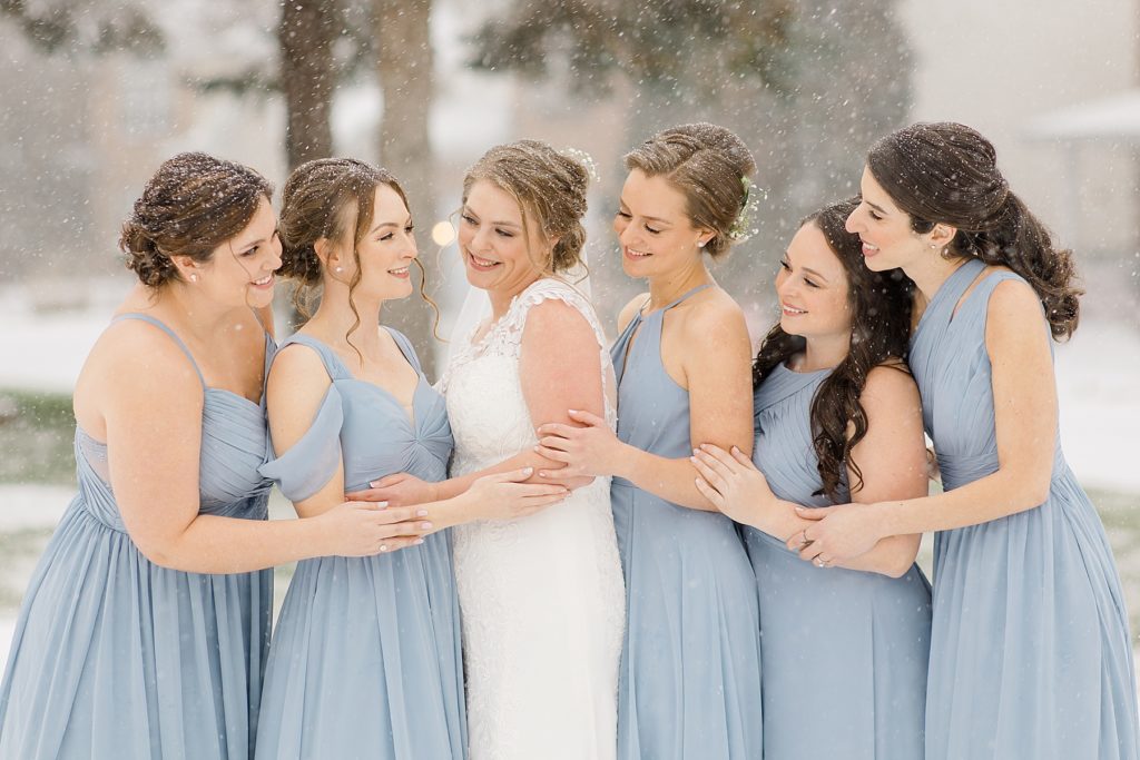 bride with bridal party in dusty blue dresses from azazie for temples country winter wedding photographed by Brittany Navin Photography